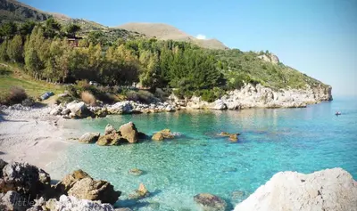 a body of water with rocks and a beach at Villa Marinella by Sicily Travelling Villas in Scopello