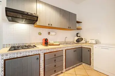 a kitchen with a stove and a counter top at Villa Berretta by Sicily Travelling Villas in Scopello