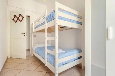 a bedroom with two bunk beds with blue sheets at Villa Berretta by Sicily Travelling Villas in Scopello