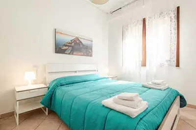 a white bedroom with a blue bed with towels on it at Villa Uzzo by Sicily Travelling Villas in Scopello