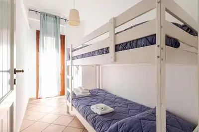 a bedroom with two bunk beds with blue sheets at Villa Varo by Sicily Travelling Villas in Scopello