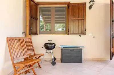 a room with a table and a grill and a chair at Villa Varo by Sicily Travelling Villas in Scopello