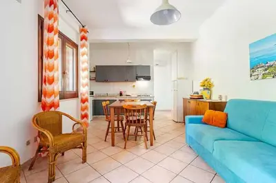 a living room with a blue couch and a table at Villa Varo by Sicily Travelling Villas in Scopello