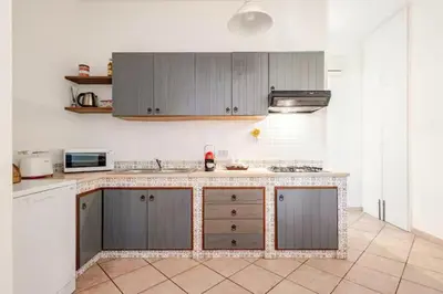 a kitchen with gray cabinets and a counter top at Villa Varo by Sicily Travelling Villas in Scopello