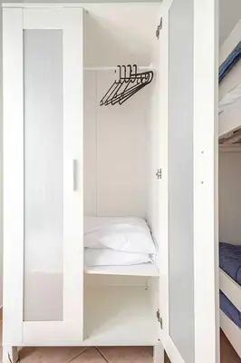 a white cabinet with a bed in a bedroom at Villa Varo by Sicily Travelling Villas in Scopello