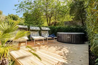 two chairs sitting on a wooden deck next to a hot tub at Villa Varo by Sicily Travelling Villas in Scopello