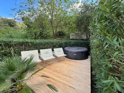 two chairs and a ottoman sitting on a wooden deck at Villa Varo by Sicily Travelling Villas in Scopello