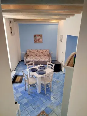 a living room with a table and chairs and a couch at Le Mura Home in Palermo
