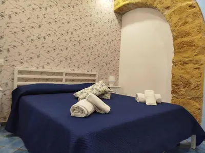 a bedroom with a blue bed with towels on it at Le Mura Home in Palermo