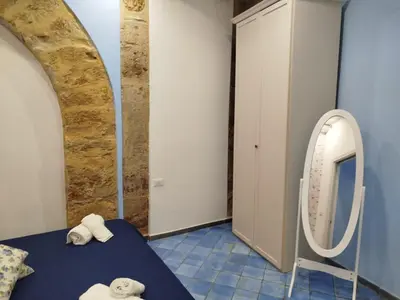 a room with a mirror and a bed with towels at Le Mura Home in Palermo