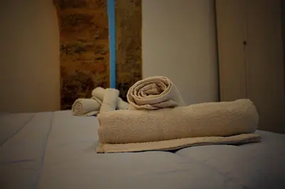 a pile of towels sitting on top of a bed at Le Mura Home in Palermo