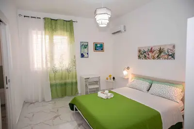 a bedroom with a green bed and a window at Azzurro Mare in Isola delle Femmine
