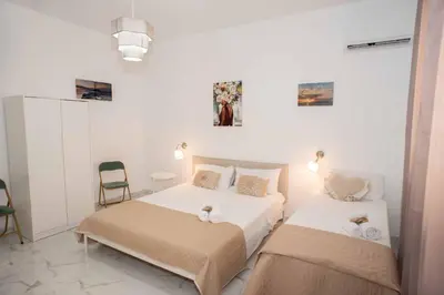 a bedroom with two beds and a chair in it at Azzurro Mare in Isola delle Femmine