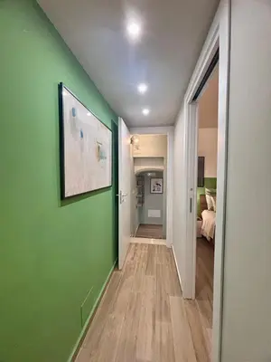 a hallway with a green wall and a bedroom at A me casa in Palermo