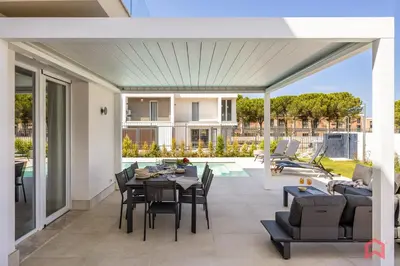an open patio with a table and chairs and a pool at Brand New Villa with Private Heated Pool in Terrasini