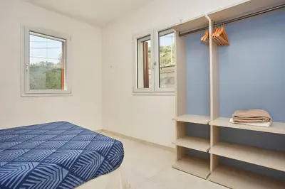 a bedroom with a bed and two windows at Le Residenze di Zio Toto' in Scopello