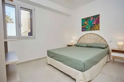 a bedroom with a bed in a room with a window at Le Residenze di Zio Toto' in Scopello