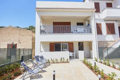 a white house with chairs and a balcony at Le Residenze di Zio Toto' in Scopello