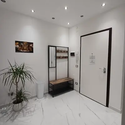 a white room with a mirror and a door at Villa Tàsca Apartment in Palermo