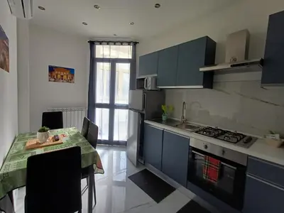 a kitchen with a table and a stove top oven at Villa Tàsca Apartment in Palermo