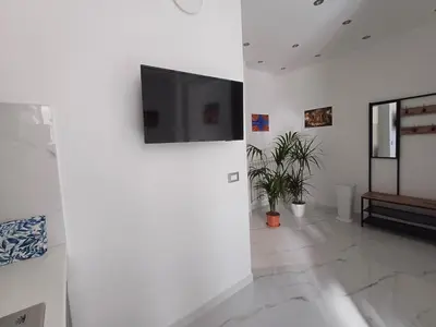 a living room with a flat screen tv on a wall at Villa Tàsca Apartment in Palermo