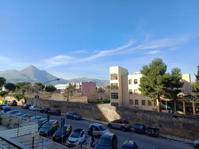 a street with cars parked in a parking lot at Villa Tàsca Apartment in Palermo