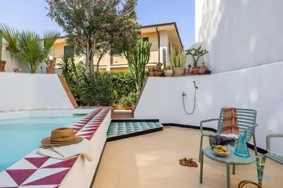a patio with a pool and a chair and a table at Verosicily Villa Damus in Terrasini