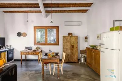 a kitchen with a table and a refrigerator at Verosicily Villa Damus in Terrasini