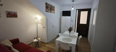 a living room with a white table and a red couch at Cozy Apartment with Stunning Mountain Views in Lascari
