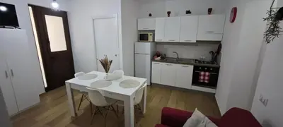 a kitchen with a white table and a white table and chairs at Cozy Apartment with Stunning Mountain Views in Lascari