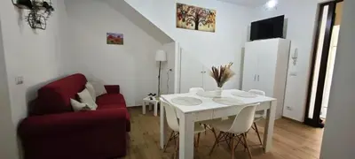 a living room with a white table and a red couch at Cozy Apartment with Stunning Mountain Views in Lascari