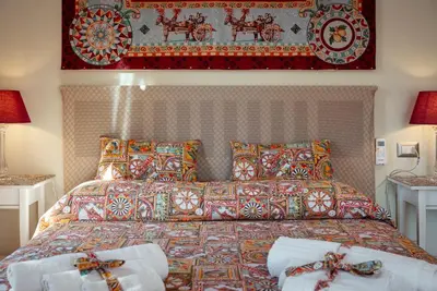 a bedroom with a bed with pillows and a blanket at Le Meraviglie della Sicilia in Palermo