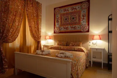 a bedroom with a bed and a large rug on the wall at Le Meraviglie della Sicilia in Palermo