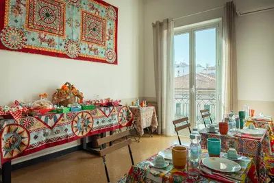 a dining room with two tables and a painting on the wall at Le Meraviglie della Sicilia in Palermo
