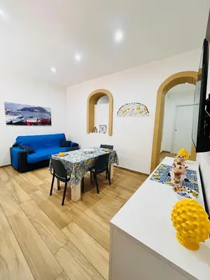 a living room with a table and a blue couch at Casa Vacanze di Maria in Palermo