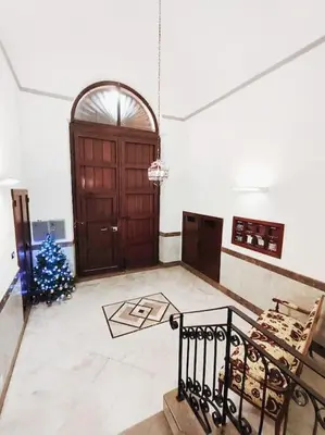 a room with a large wooden door and a christmas tree at Mansarda di Gabriella al Politeama - City center in Palermo