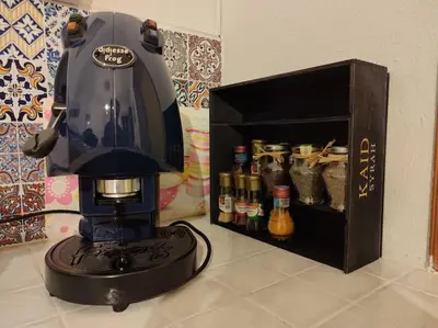 a black coffee maker sitting on a counter next to a shelf at Mansarda di Gabriella al Politeama - City center in Palermo