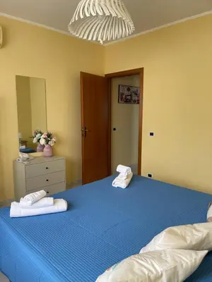 a bedroom with a blue bed with towels on it at Sicily Holiday Home in Termini Imerese
