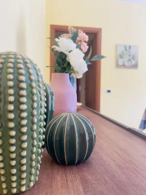 two green vases and a vase with flowers on a table at Sicily Holiday Home in Termini Imerese