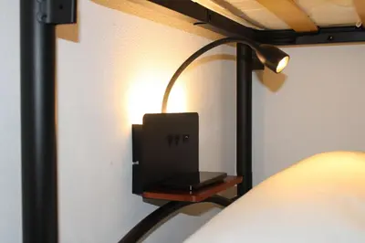 a lamp on a wall next to a bed at Pillis House, accogliente appartamento in centro città, vicino al Politeama Palermo in Palermo