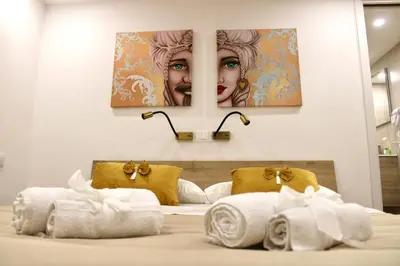 a bed with towels and a picture of a woman at Pillis House, accogliente appartamento in centro città, vicino al Politeama Palermo in Palermo
