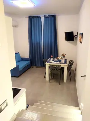 a small living room with a table and a blue couch at Palermo Holiday Room in Palermo