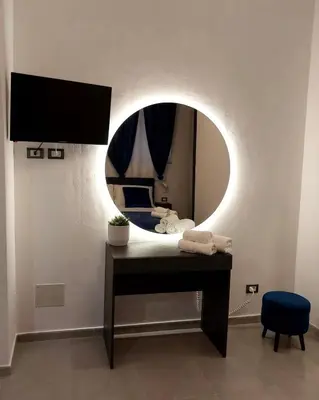 a room with a bed with a mirror and a table at Palermo Holiday Room in Palermo