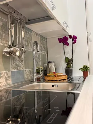 a kitchen with a sink and flowers on the counter at Garzilli Cozy Apartment in Palermo