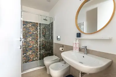 a bathroom with a sink and a toilet and a mirror at Casa Lolli by Wonderful Italy in Palermo