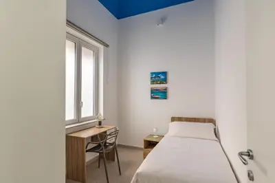 a bedroom with a bed and a desk and a window at Casa Lolli by Wonderful Italy in Palermo