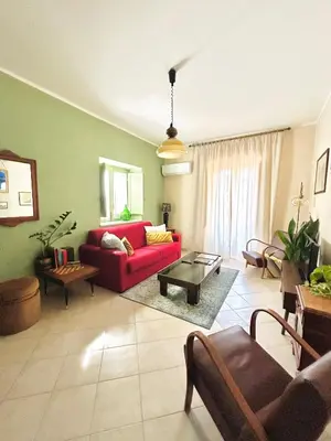 a living room with a red couch and a table at Fajra house in Palermo