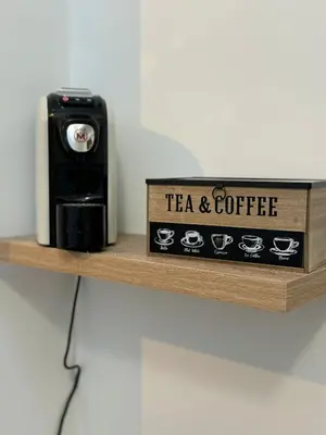 a wooden shelf with a tea and coffee clock on it at bonito apartment in Palermo