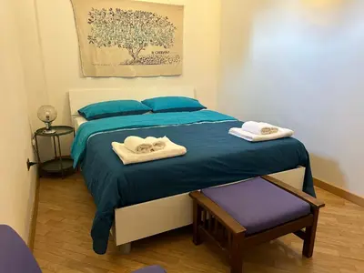 a bedroom with a bed with blue sheets and towels at Glicine House in Palermo