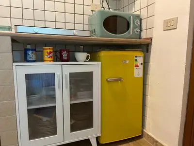 a yellow refrigerator and a microwave in a kitchen at Glicine House in Palermo